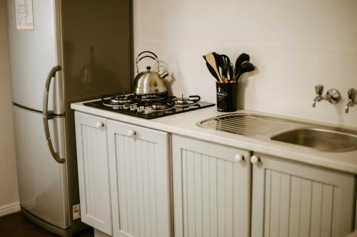 a kitchen with a stove and a sink next to a refrigerator at 62 on Adderley in George
