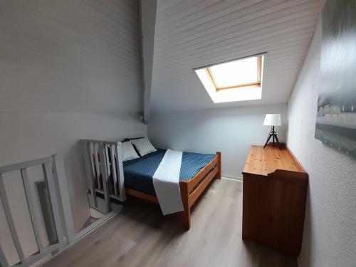 - une petite chambre avec un lit et une lucarne dans l'établissement Studio Duplex Moliets, à Moliets-et-Maa