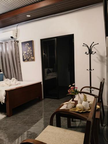 a room with a bed and a table and a dining room at Goldland Caelestis Guest House in Bacolod