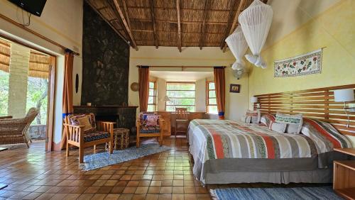 a bedroom with a bed and a table and chairs at Musangano Lodge in Odzi