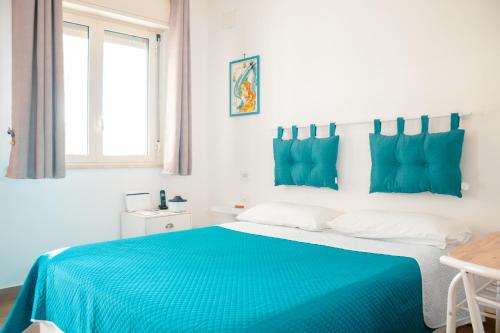 a bedroom with a bed with blue sheets and a window at Villa Torre Ulisse Locazione Turistica Affitti Brevi in Carini