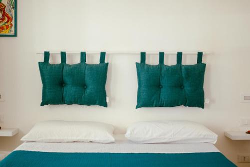 a bedroom with two green pillows and a bed at Villa Torre Ulisse Locazione Turistica Affitti Brevi in Carini