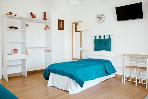 a bedroom with a blue bed and white walls at Villa Torre Ulisse Locazione Turistica Affitti Brevi in Carini