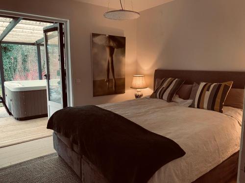 a bedroom with a bed and a sliding glass door at Delicious pool villa near Tylösand in Halmstad
