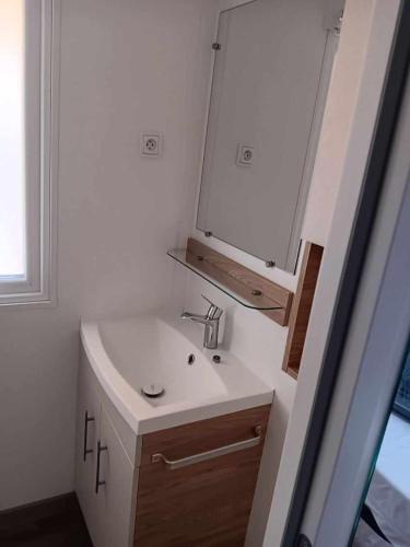 une salle de bain avec un lavabo et un miroir dans l'établissement MH306 - Charmettes, aux Mathes