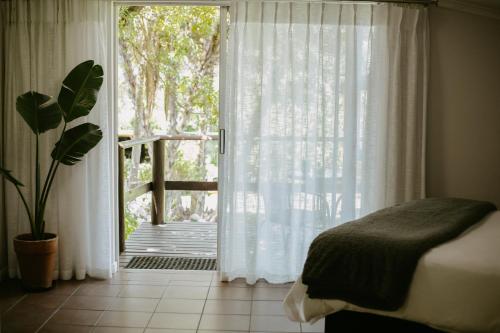 a bedroom with a bed and a door to a balcony at 62 on Adderley in George