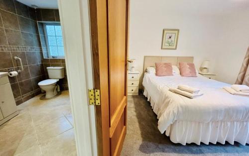 une chambre avec un lit et une salle de bain avec WC dans l'établissement Cosy bungalow in Pembrokeshire, à Pembroke