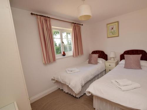 une chambre avec deux lits et une fenêtre dans l'établissement Cosy bungalow in Pembrokeshire, à Pembroke