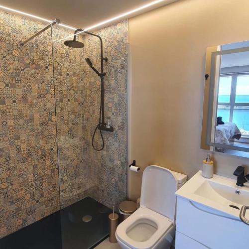 a bathroom with a shower and a toilet and a sink at Center Marina view Gold Studio in Funchal