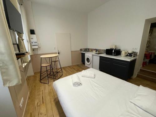 Cette chambre comprend une petite cuisine avec un lit blanc. dans l'établissement Studio Rénové centre Riom au calme, à Riom