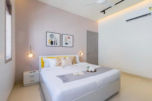 a white bedroom with a large white bed in it at ELIVAAS Shourya Sereno - Luxe 4 BHK Villa With Pvt Pool & Garden in Lakāwās