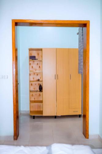 キガリにあるRUBIRIZI Residenceの木製のキャビネット付きの部屋への開放ドア