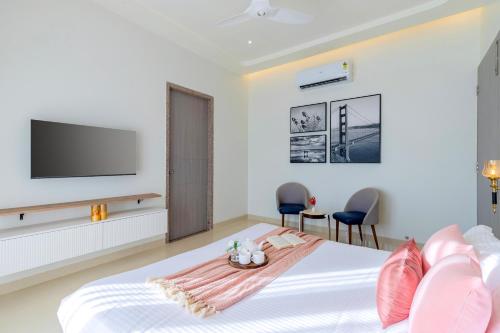 a bedroom with a bed with a flat screen tv at ELIVAAS Shourya Sereno - Luxe 4 BHK Villa With Pvt Pool & Garden in Lakāwās