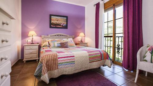 フリヒリアナにあるVilla Franciscoの紫の壁のベッドルーム1室、ベッド1台、窓が備わります。