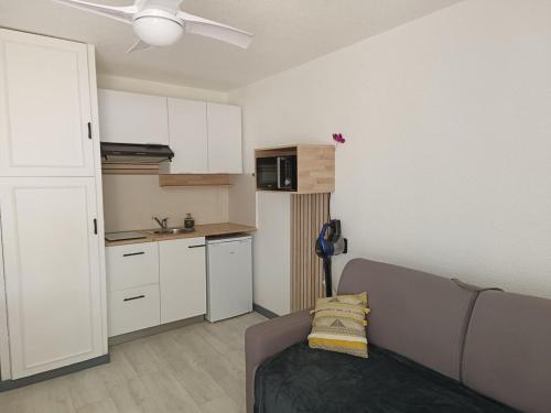 un salon avec un canapé et une cuisine dans l'établissement Studio La Favière Bormes les Mimosas, à Bormes-les-Mimosas