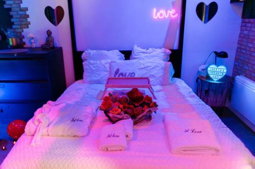 - une chambre avec un lit et un bouquet de roses dans l'établissement Escapade Romantique avec Champagne offert, à Meaux