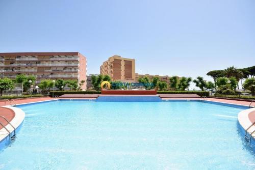 a large swimming pool in the middle of a city at Apartamento acogedor en primera línea de playa in La Pineda