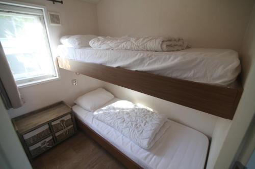 two bunk beds in a room with a window at Chalet park Kroondomein Giethoorn in Giethoorn