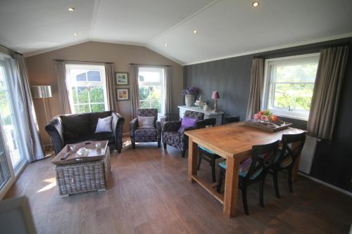 a living room with a wooden table and chairs at Chalet park Kroondomein Giethoorn in Giethoorn