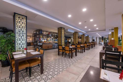 a dining room with tables and chairs in a restaurant at Asteria Collection Side in Side