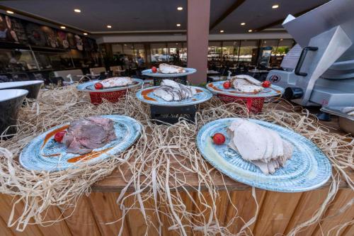 a table with plates of food on top of hay at Asteria Collection Side in Side