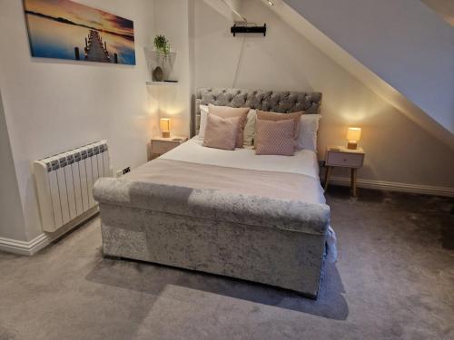 a bedroom with a large bed with two lamps at Harbour View apartment in Portreath in Portreath
