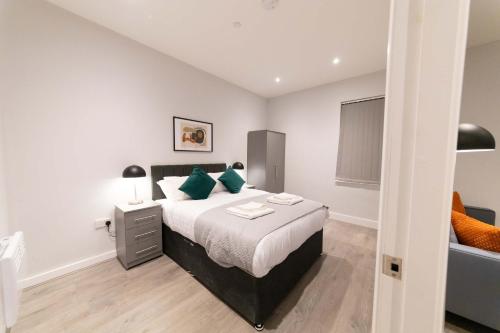 a bedroom with a large bed with green pillows at Convenient 2 Bed Apartment in Waterloo Liverpool in Waterloo