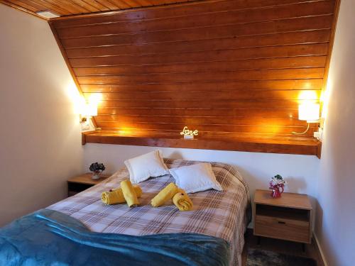 a bedroom with a bed with a wooden headboard at Chalé Zimbro, Serra da Estrela, Penhas da Saúde in Penhas da Saúde