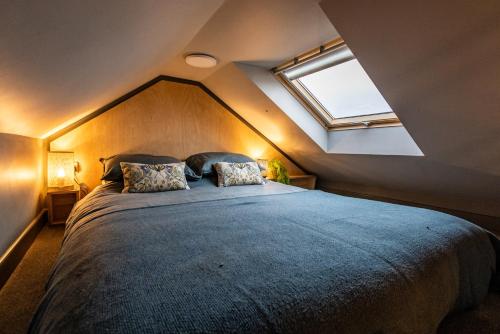 a bedroom with a large bed with a skylight at Jura - The Black Hut in Isle of Jura