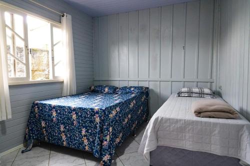 a bedroom with two beds and a window at Nete Getaway! in Palhoça