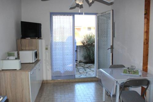 - un salon avec une porte s'ouvrant sur une terrasse dans l'établissement Pavillon climatisé avec parking - 5 couchages - 5CIGAL27, à Saint Cyprien Plage