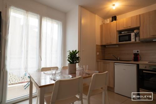 une cuisine avec une table et des chaises et une cuisine avec une fenêtre dans l'établissement Vias-Plage - Large T1 100m from the beach, à Vias