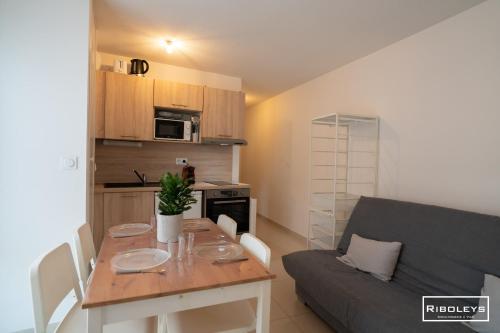 un petit salon avec une table et un canapé dans l'établissement Vias-Plage - Large T1 100m from the beach, à Vias