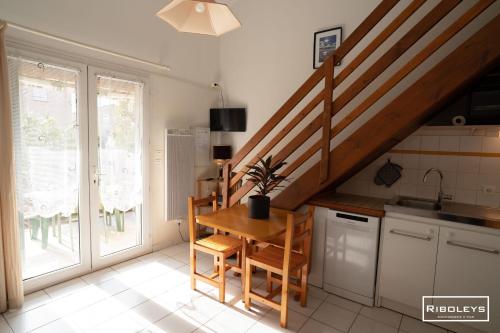une cuisine avec une table en bois et un escalier dans l'établissement Maison de vacances à 600m de la plage, à Vias