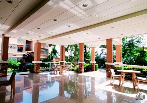 a lobby with tables and chairs in a building at Palawan Luxury 2BR Condo with Pool, Gym & Parking - B1 5Kunzite in Puerto Princesa City