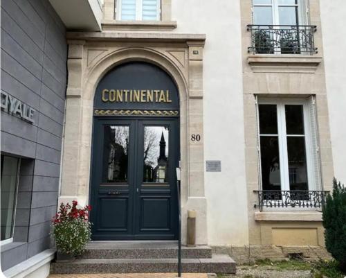 una entrada a un edificio con una puerta azul en jolie studio meublé 407, en Vittel