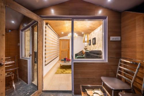 a room with wooden walls and a large window at Anastasia in Shimla