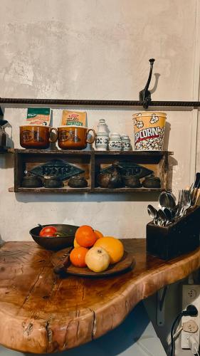 a wooden table with a plate of fruit on it at הבית החום יחידת אירוח לזוגות ומטיילים בערבה in Sappir