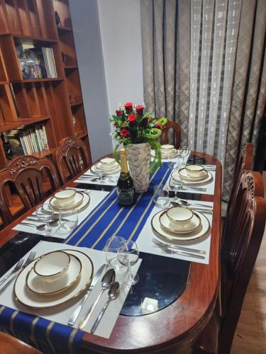 a table with plates and silverware on it at Goldland Caelestis Guest House in Bacolod