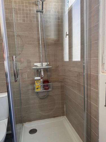 une douche avec une porte en verre et des toilettes. dans l'établissement Quiet apartment hill of Montmartre, à Paris