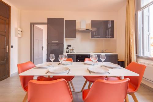 a dining room with a white table and orange chairs at Appartement moderne et élégant Michel Torrent 2 in Perpignan
