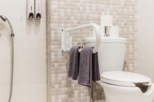 a bathroom with a toilet and a shower with towels at Infinity Hotel Gytheio in Gythio