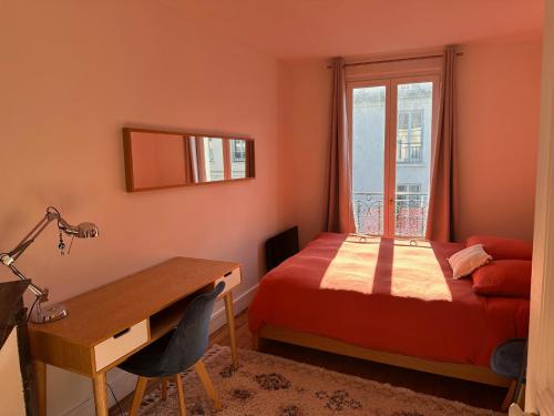 une chambre avec un lit, un bureau et une fenêtre dans l'établissement Quiet apartment hill of Montmartre, à Paris