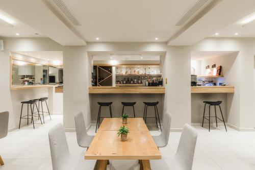 a dining room with a wooden table and chairs at Infinity Hotel Gytheio in Gythio
