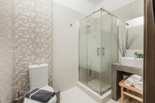 a bathroom with a shower and a toilet and a sink at Infinity Hotel Gytheio in Gythio