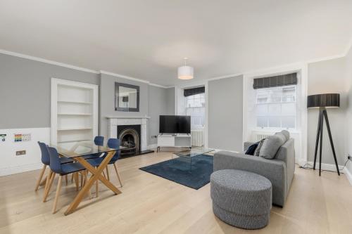 a living room with a table and chairs and a television at Destiny Scotland - Hill Street Apartments in Edinburgh