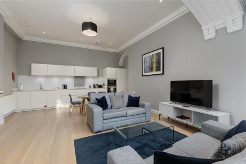 a living room with two couches and a tv at Destiny Scotland - Hill Street Apartments in Edinburgh