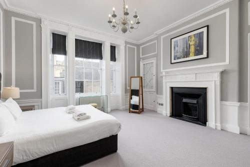 a white bedroom with a bed and a fireplace at Destiny Scotland - Hill Street Apartments in Edinburgh