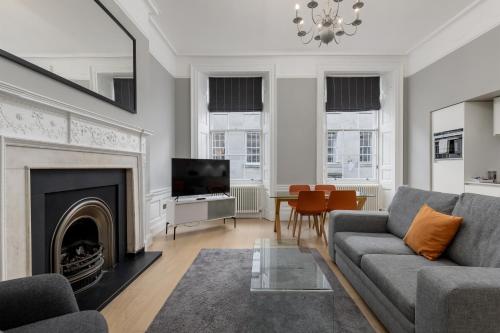 a living room with a couch and a fireplace at Destiny Scotland - Hill Street Apartments in Edinburgh