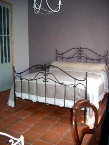 a bedroom with a metal bed in a room at Buisson gîte et chambre d'hôte in Laruscade